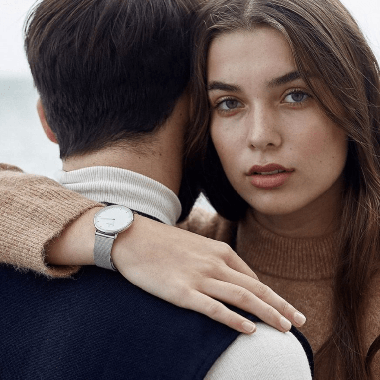 Ethical jewellery from Nordgreen- a female with her arm over a mans shoulder, showcasing a metal watch